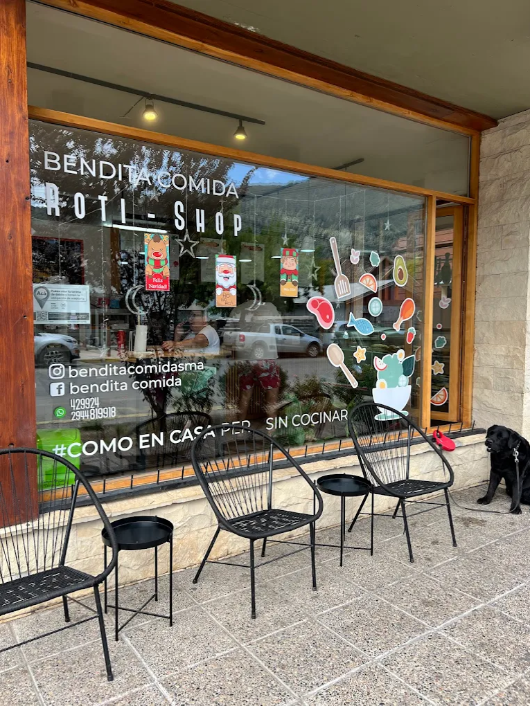 Bendita Comida - Fachada del local, vidriera grande y sillas en la vereda del local.