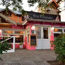 Don Florencio - Edificio de paredes de madera pintadas de rosa con puertas ventanas y puertas blancas vidriadas, techo a dos aguas.