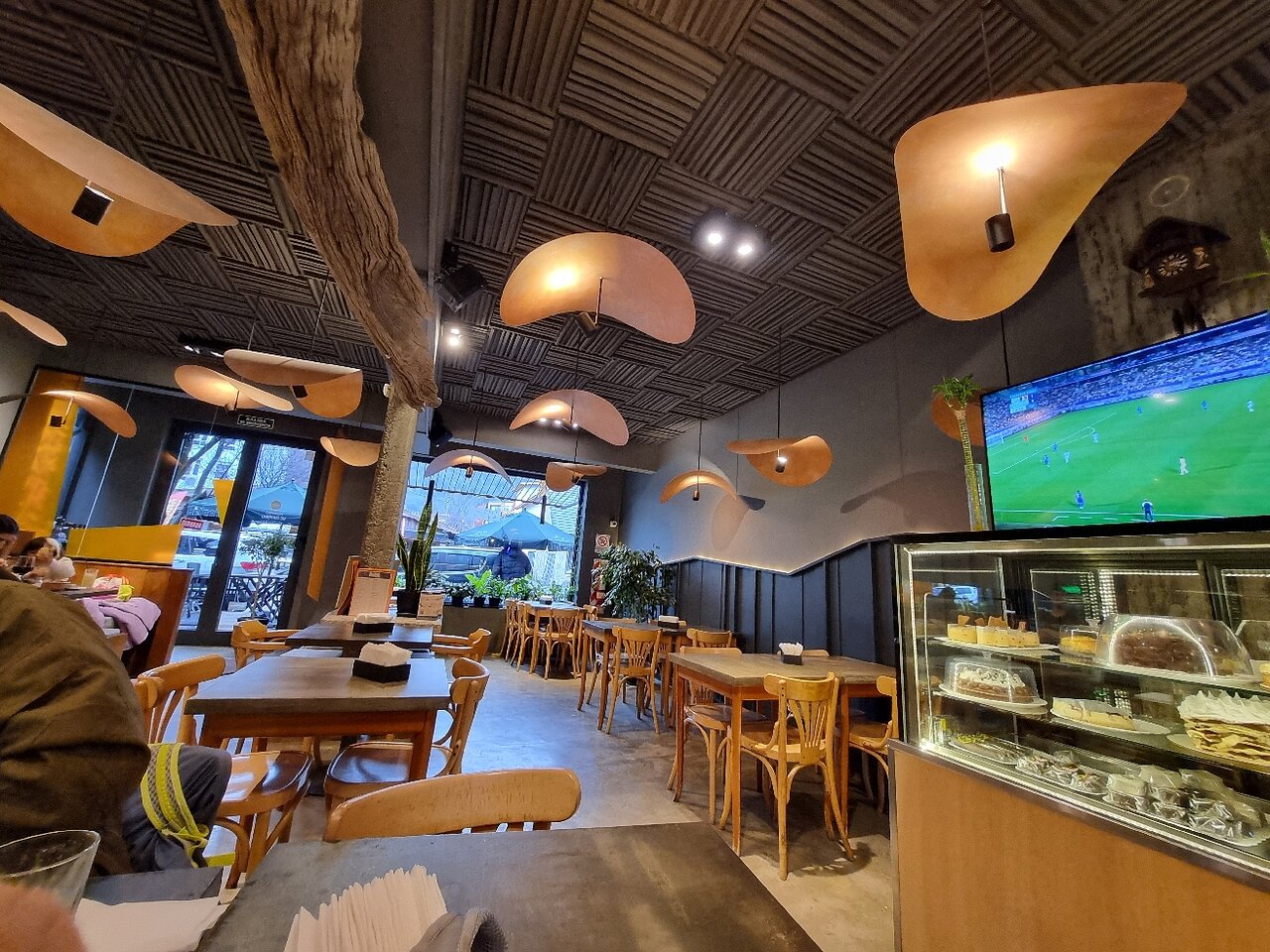 Luisa Pucará - Interior de restaurante con detalles en madera , sillas mesas, techo. Una vitrina con pastelería