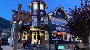 Piedra Buena - Edificio muy pintoresco estilo alpino, construido en madera pintada de colores oscuros y ventanas con marcos blancos.