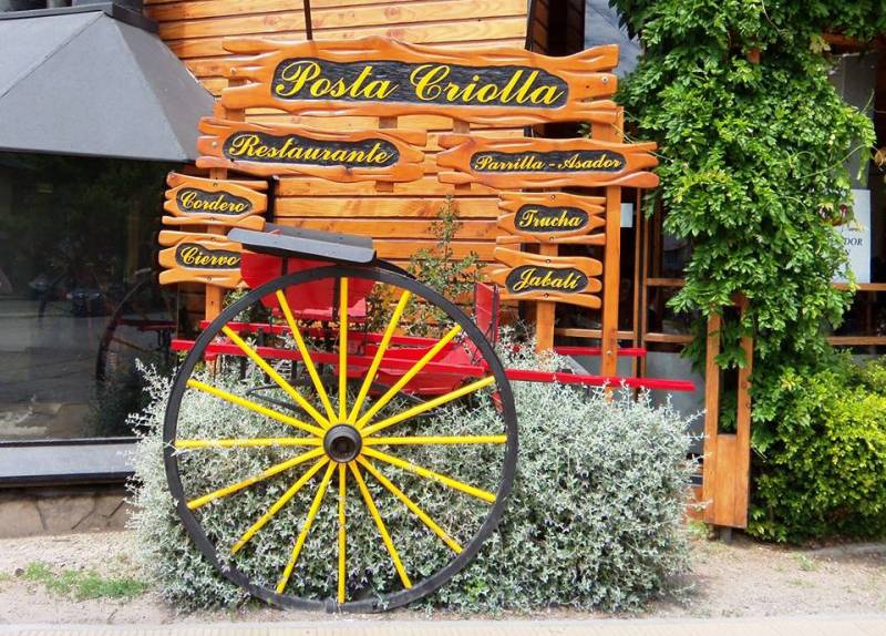 Posta Criolla - Exterior del restaurante Pota Criolla, se ve el cartel con el nombre del establecimiento y de decoración una rueda de carro.