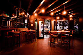 El Regional Wild - Interior de un restaurante con luz tenue de noche, mobiliario pisos y paredes de madera.