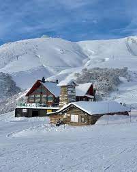 Refugio Graef Bar - Restaurante tipo cabaña rustica de madera en medio e la montaña con mucha nieve en los alrededores y techos.