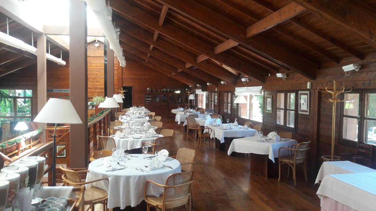 Rincon Gourmet - Interior de restaurante con pisos, paredes, mesas y sillas de madera. Las mesas redondas vestidas para un evento con manteles blancos y los utensilios necesarios.