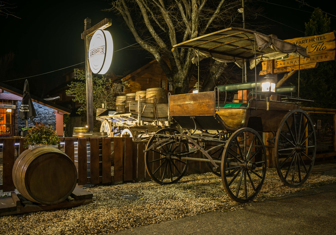 Las Barricas - Entrada al restaurante Las Barricas, con elementos de época como barriles de vino y un carro.