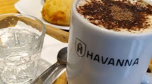 Havanna - Un café en taza servido en una mesa de confitería.