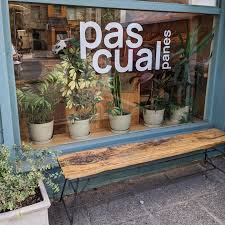 Pascual Panes - Vidriera de pastelería con el nombre Pascual Panes, detrás del vidrio se ven plantas ornamentales.
