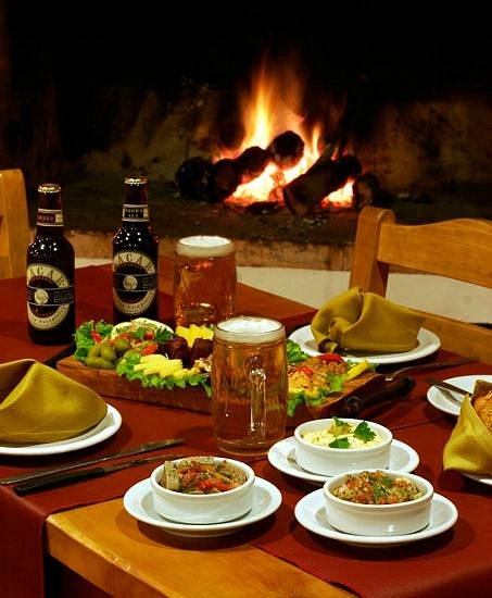 Porthos Pub - Mesa de madera servida con comidas típicas.