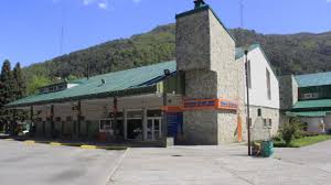 Terminal Patagonia - Edificio revestido en piedras con techos a dos aguas color verde.