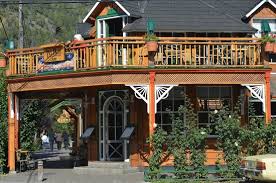 Tío Paco - Edificio en esquina con techo negro, paredes de madera y ventanas blancas.