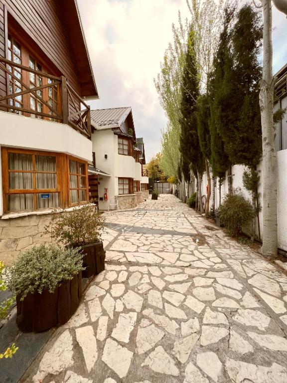 Cabañas en dos plantas, planta baja paredes recubiertas de piedra, planta alta balcón y paredes de madera, techos a dos aguas y patio en piedras lajas.