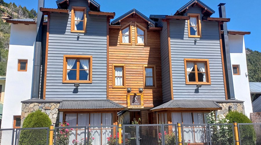 Cuatro cálidas cabañas realizadas en madera natural y en sectores pintadas en color celeste oscuro, construcción en 3 plantas con techos a dos aguas y lucarnas ubicadas en el centro de la ciudad.