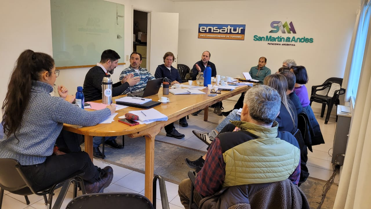 En la foto se puede ver gente reunida alrededor de una mesa de trabajo. 