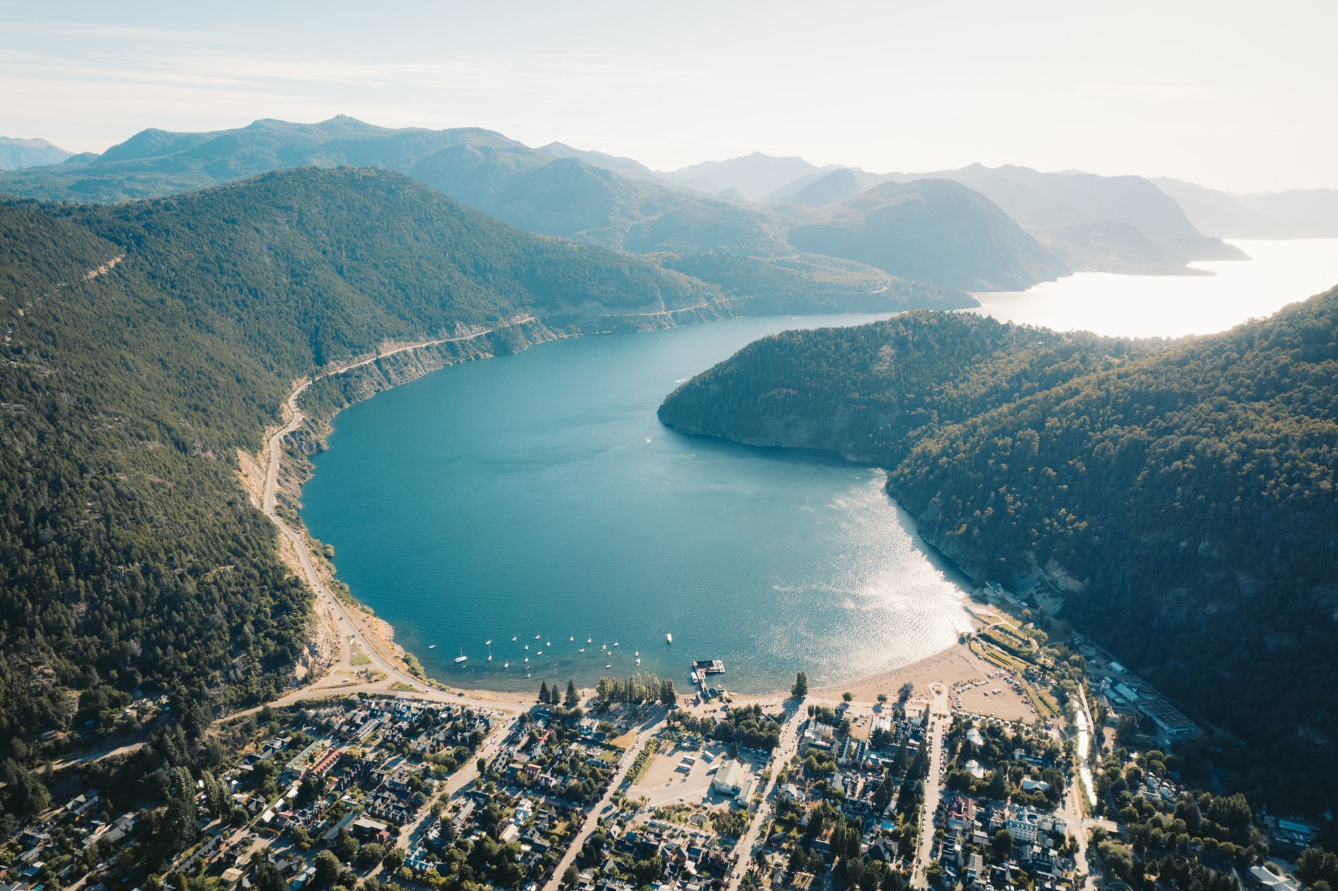 Foto aerea de la ciudad, se pueden ver montañas y un lago.